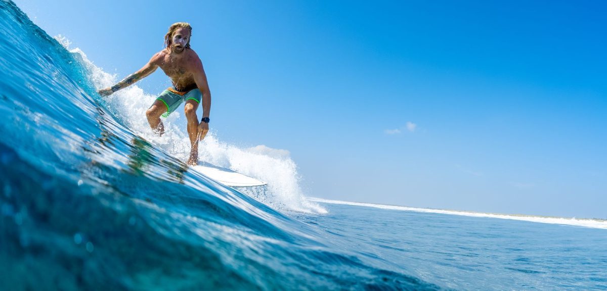 man surfing in New Smyrna Beach during summer vacation